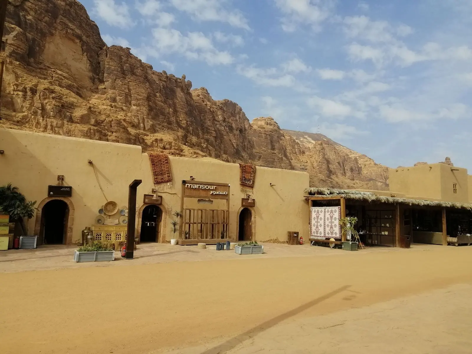 مبانٍ طينية منخفضة أمام منحدرات صخرية في العلا